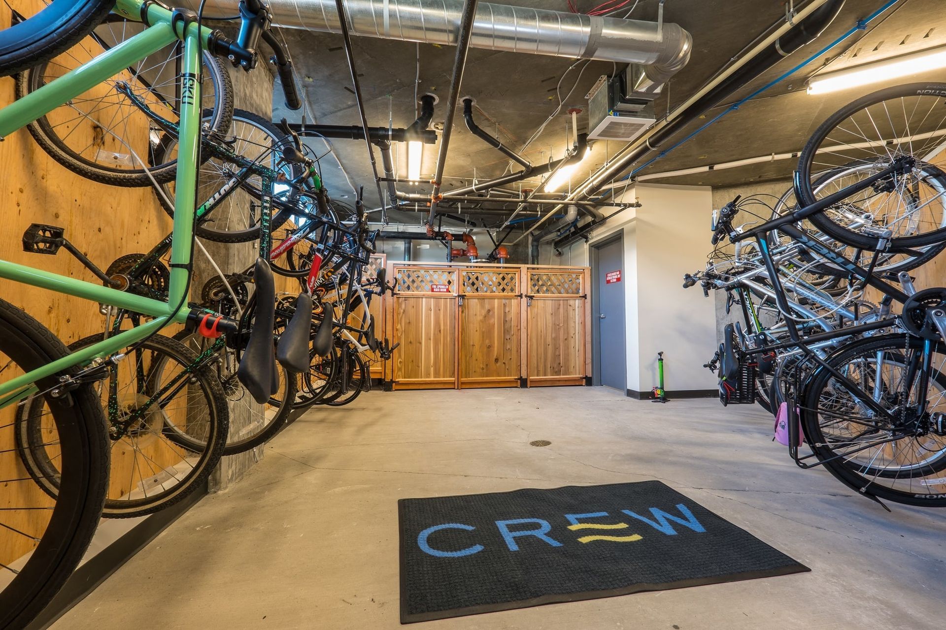 A bunch of bikes are stacked on top of each other in a garage at CREW Apartments in Seattle, WA.