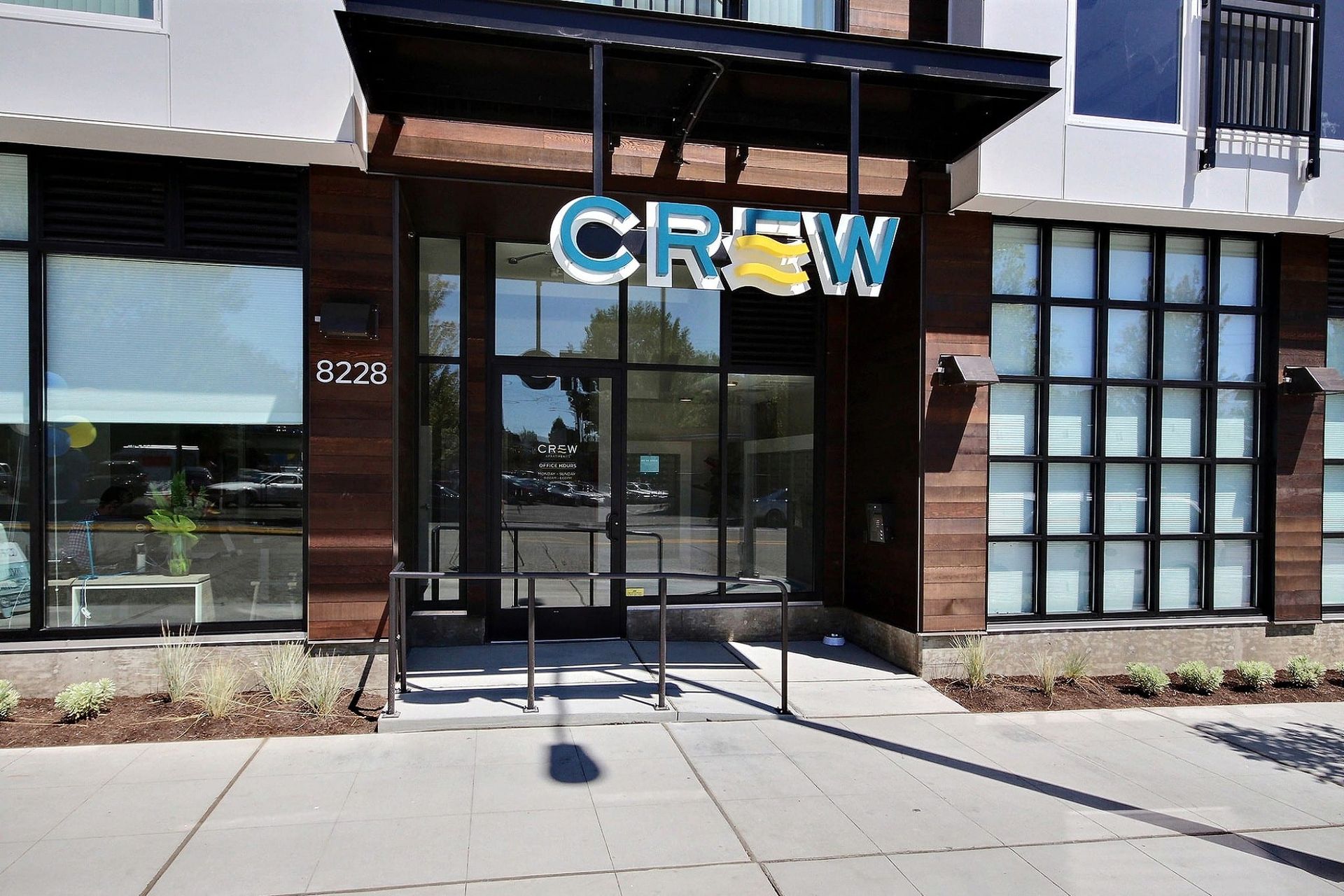 A building with a sign that says crew on it at CREW Apartments in Seattle, WA.