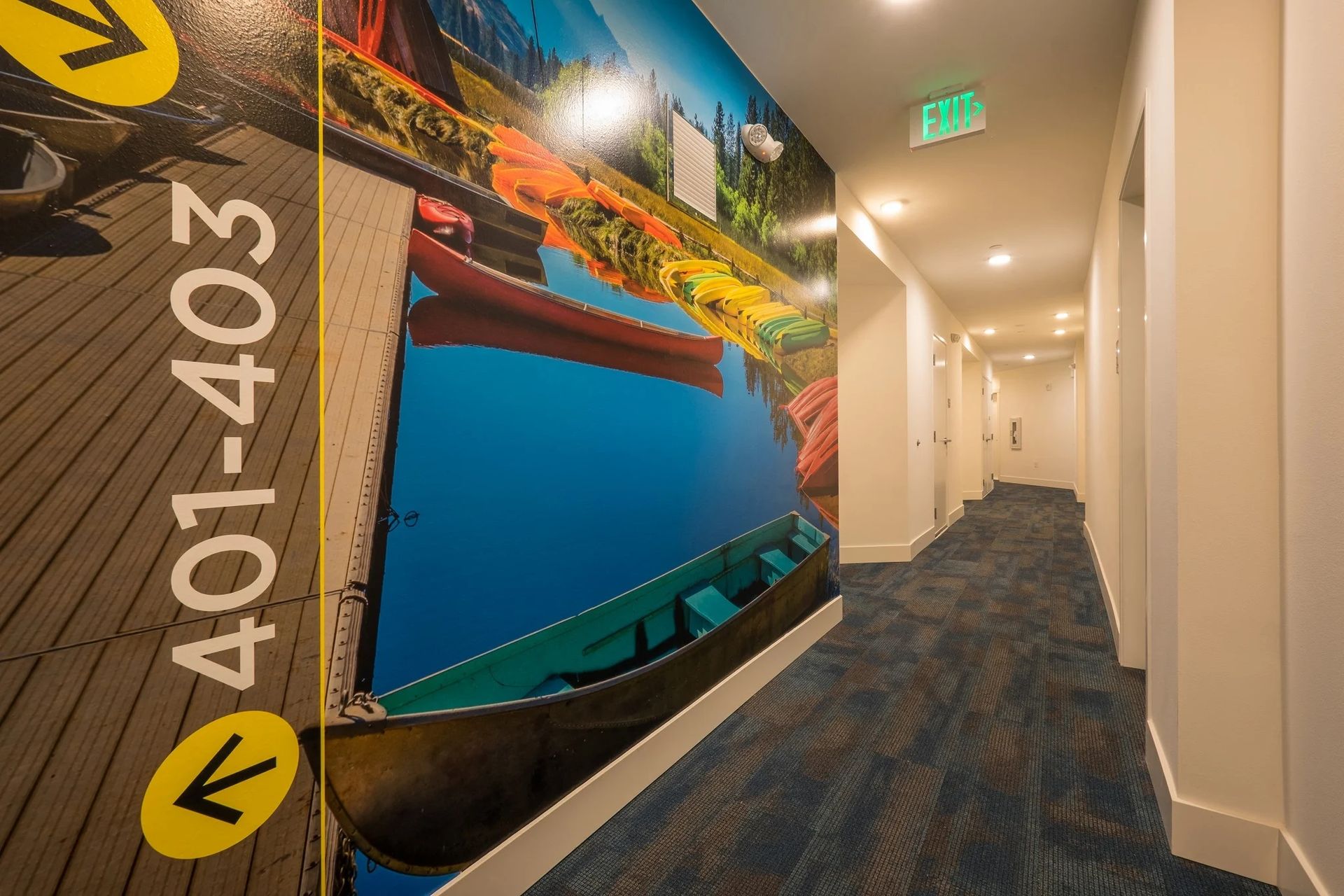 A hallway with a mural on the wall that says 401-403 at CREW Apartments in Seattle, WA.