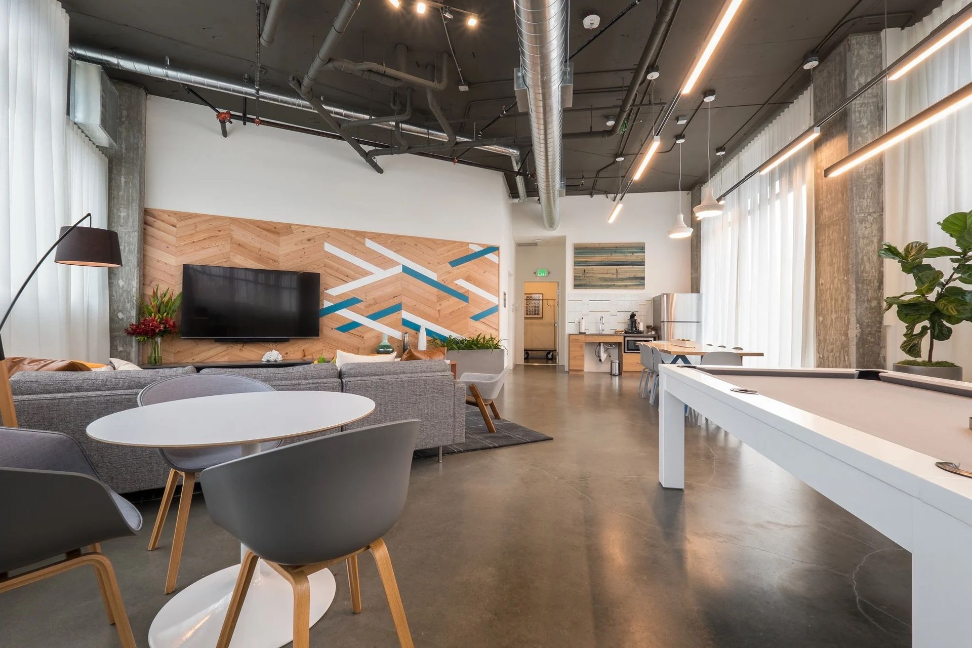There is a pool table in the middle of the room at CREW Apartments in Seattle, WA.