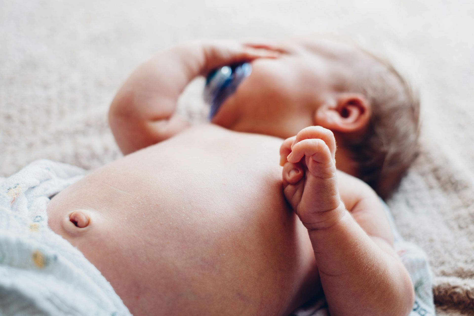 Baby sleeping  safely on back with pacifier in mouth