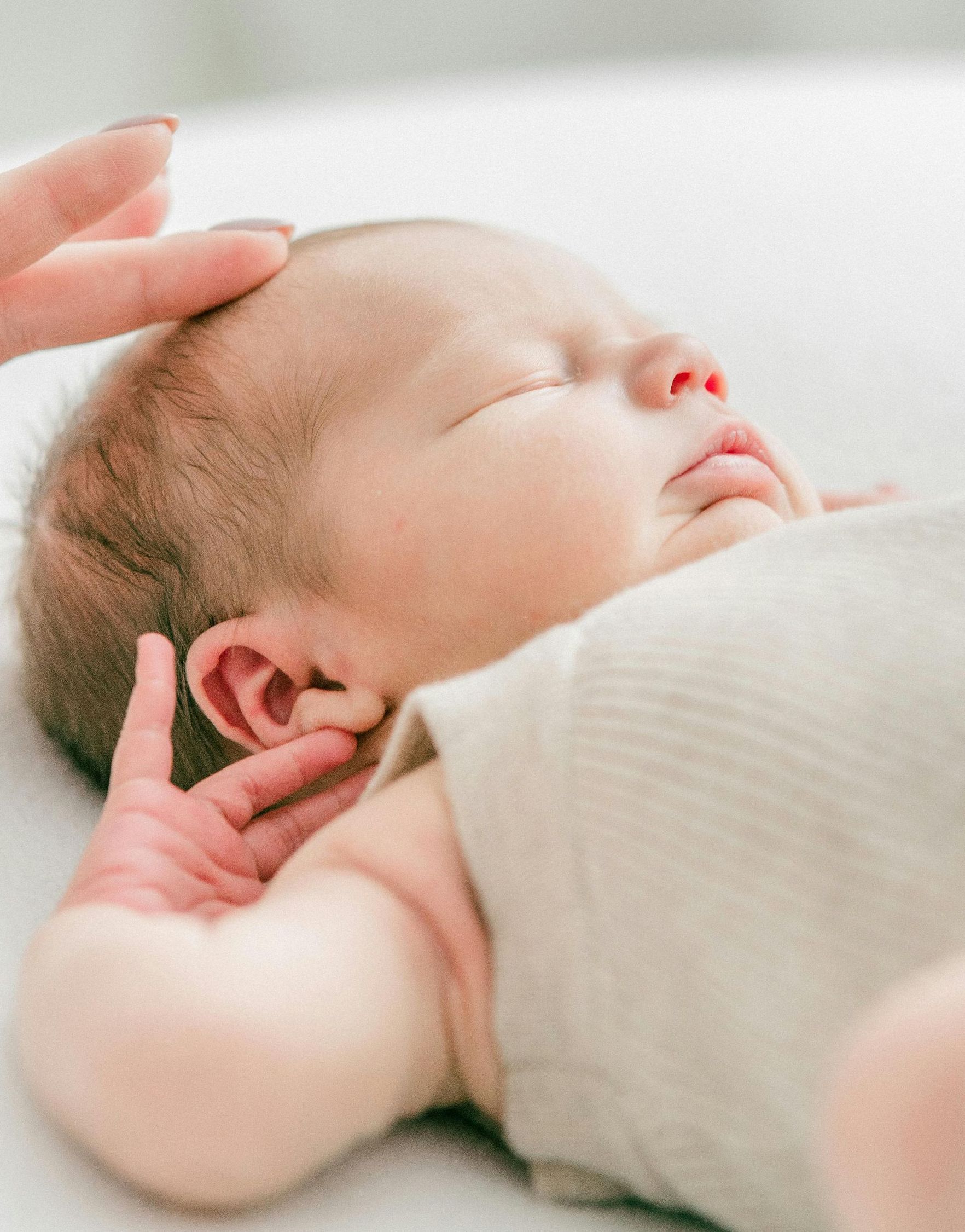 A baby learning to fall asleep independently with help from his mom