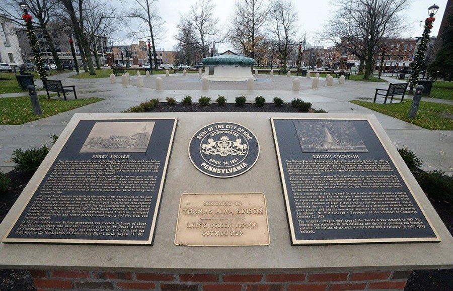 A plaque in a park with a city seal on it