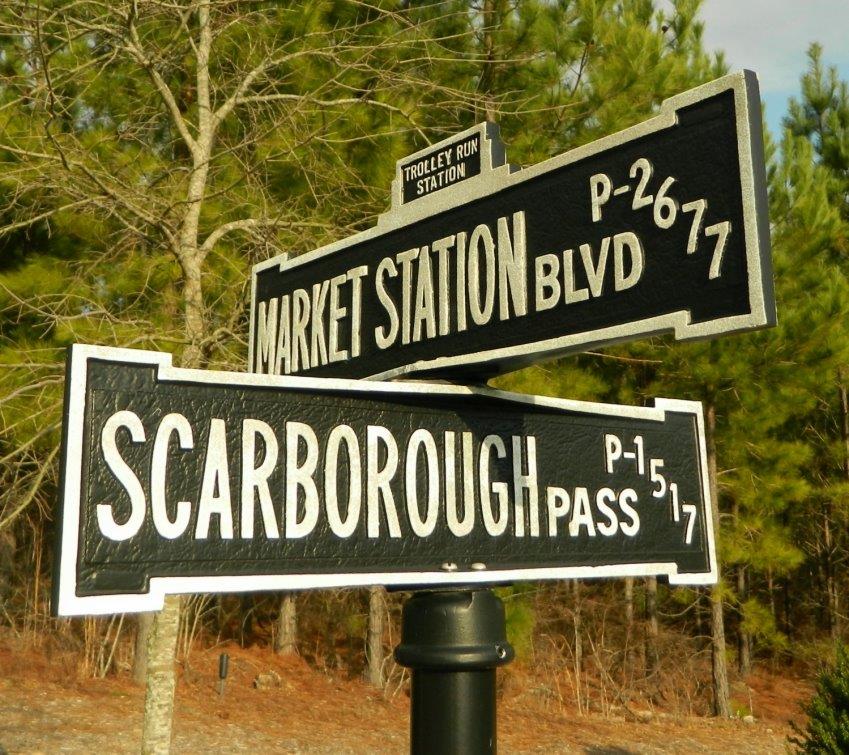A street sign for market station blvd and scarborough pass