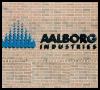 The logo for aalborg industries is on a brick wall.