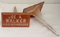 A wooden sign with the name joe a. walker on it is sitting next to a metal object.