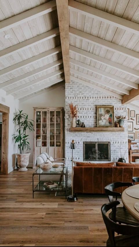 A living room with a fireplace and a vaulted ceiling.