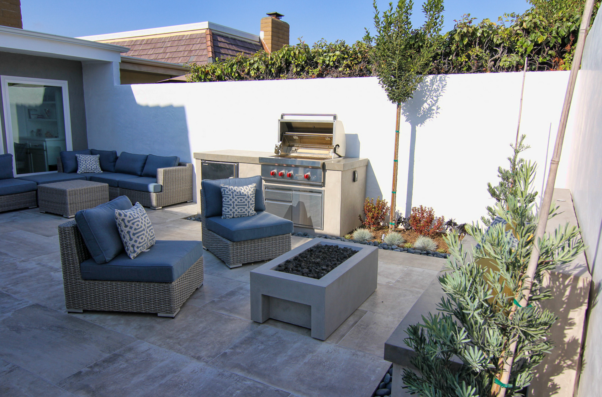A patio with a fire pit and a grill