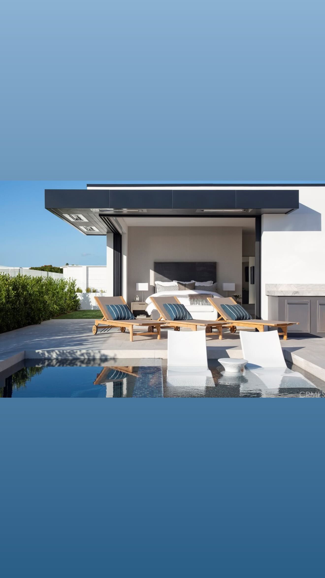 There is a swimming pool in the backyard of a house.