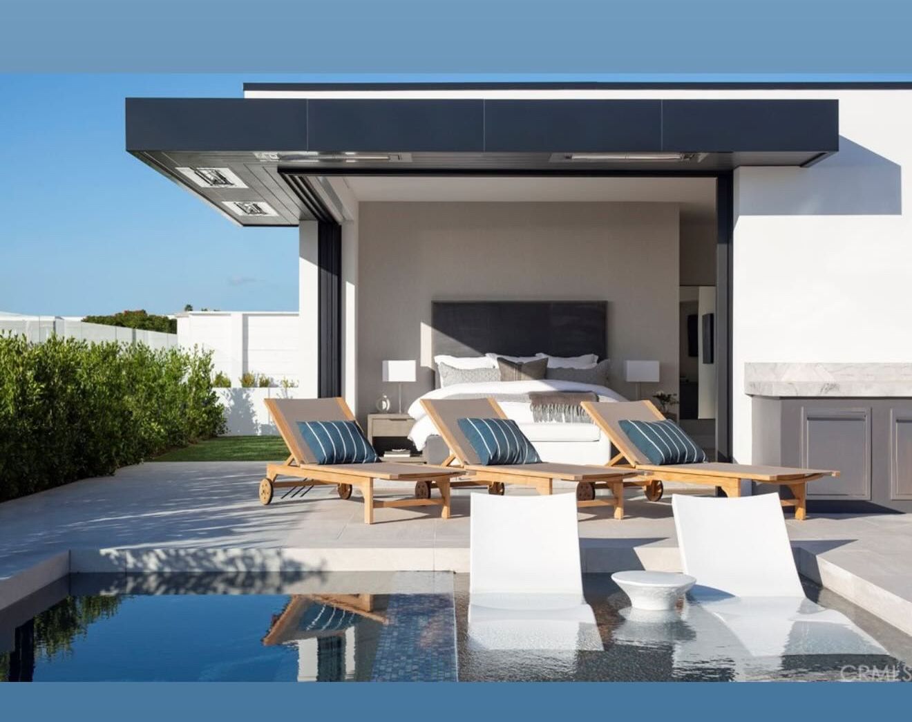A large swimming pool with a waterfall and a fire pit