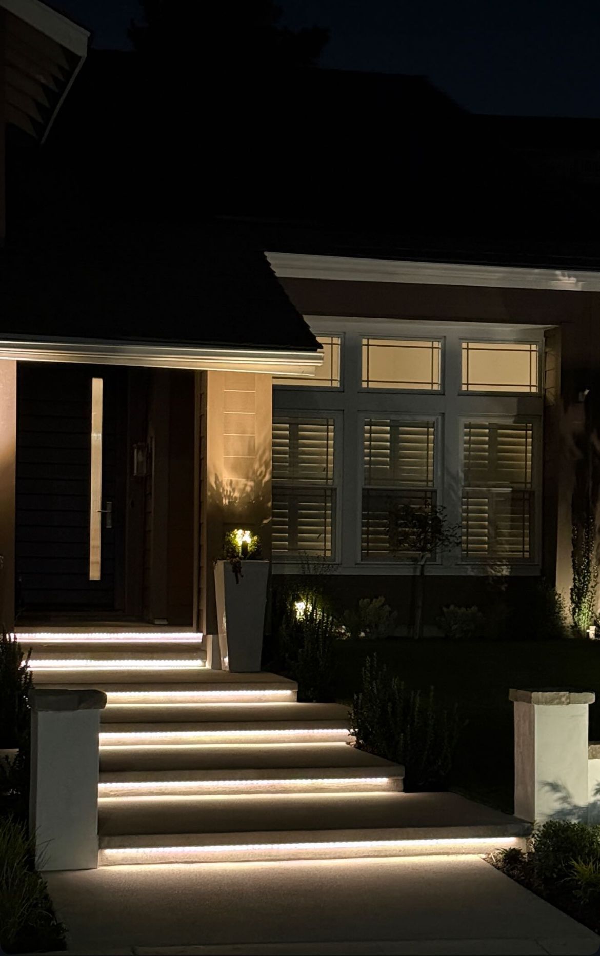 A house with stairs that are lit up at night.