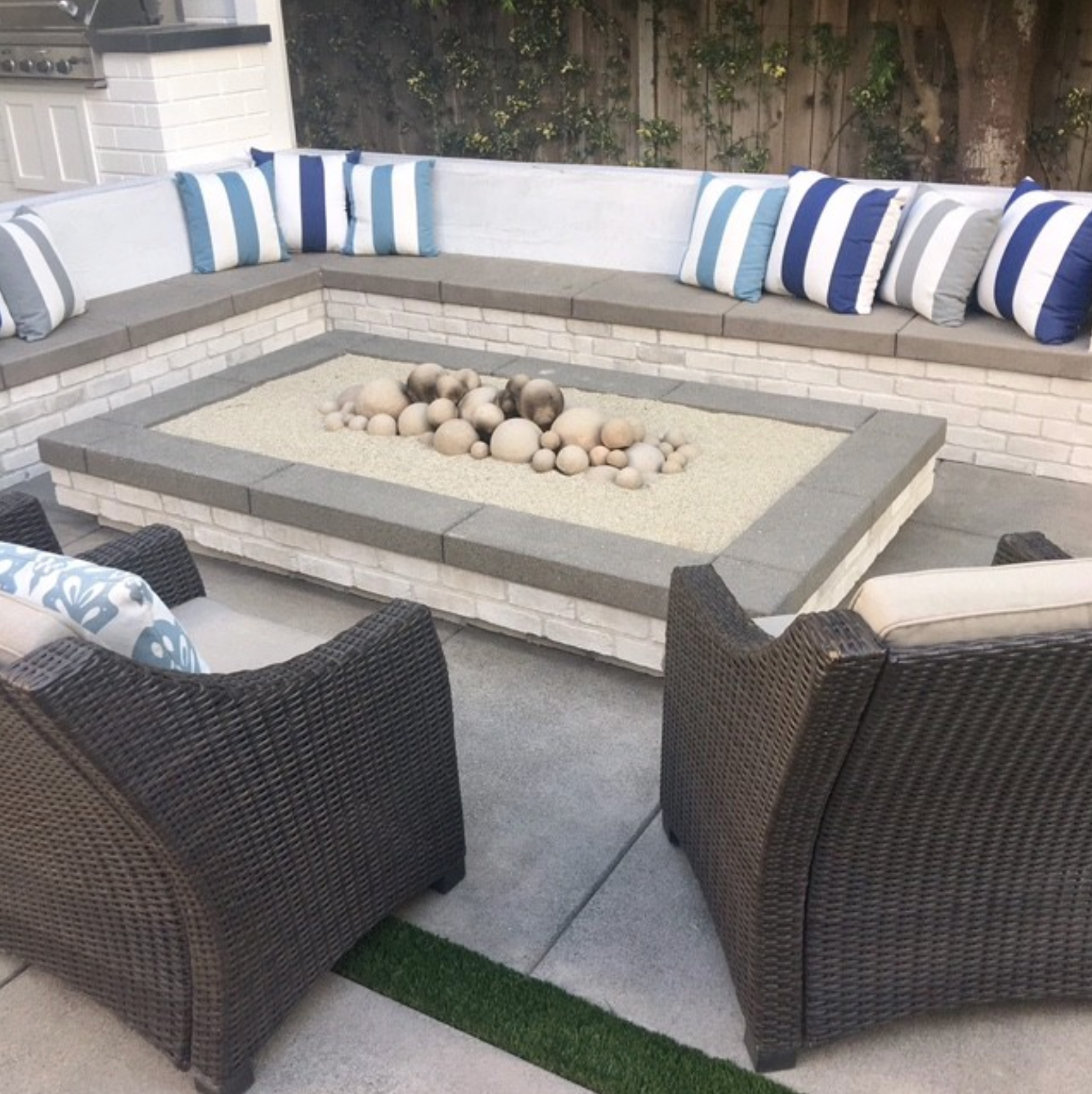 A patio with wicker furniture and a fire pit