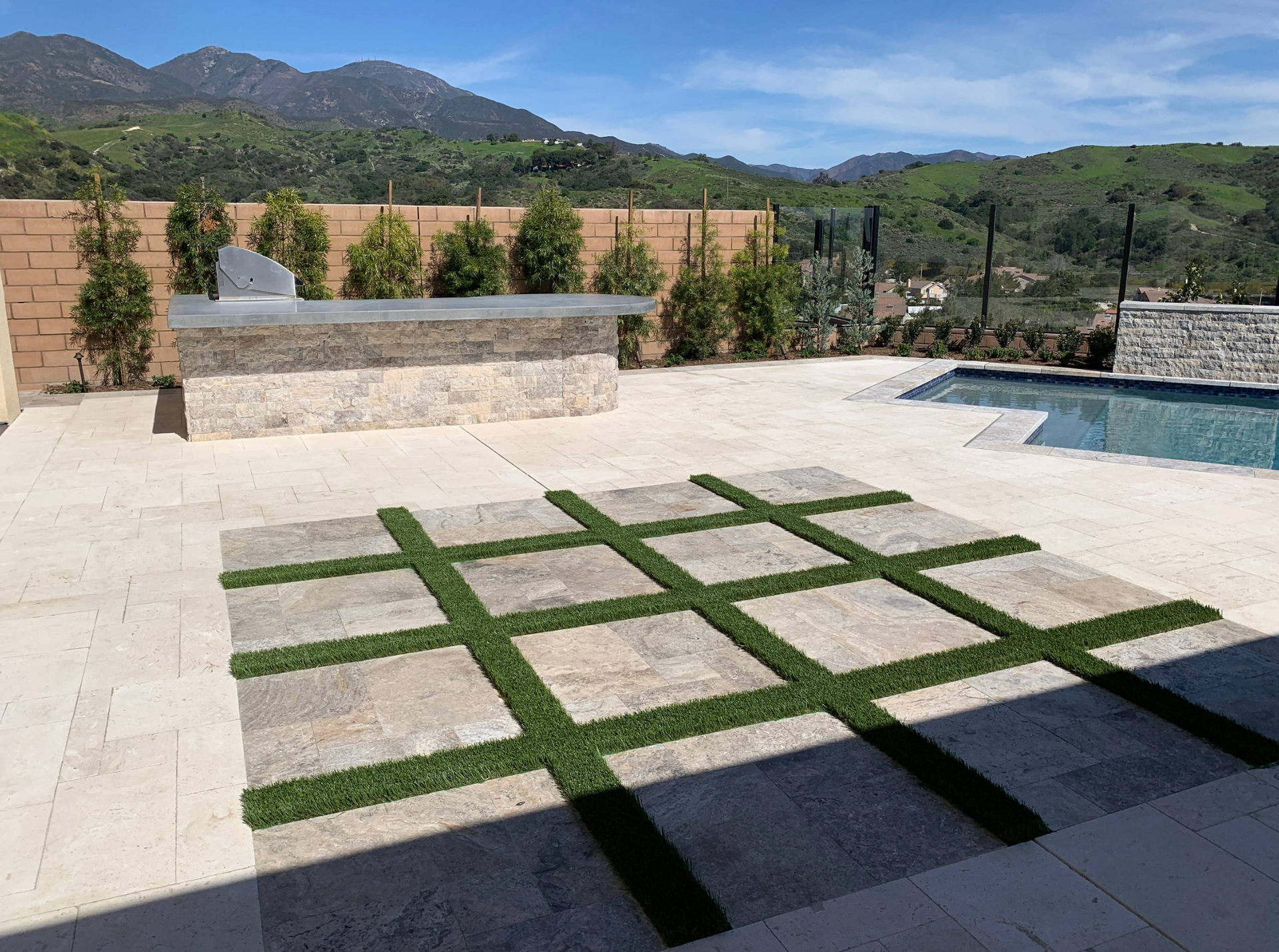 A patio with a pool and mountains in the background
