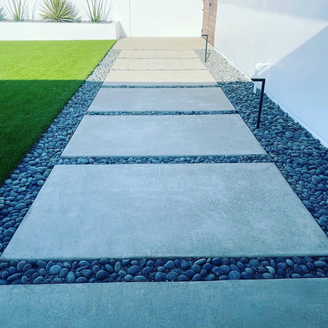 A concrete walkway surrounded by rocks and grass.