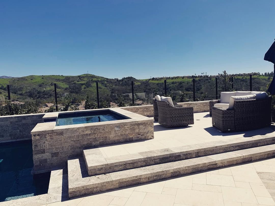 A patio with a swimming pool and chairs and umbrellas