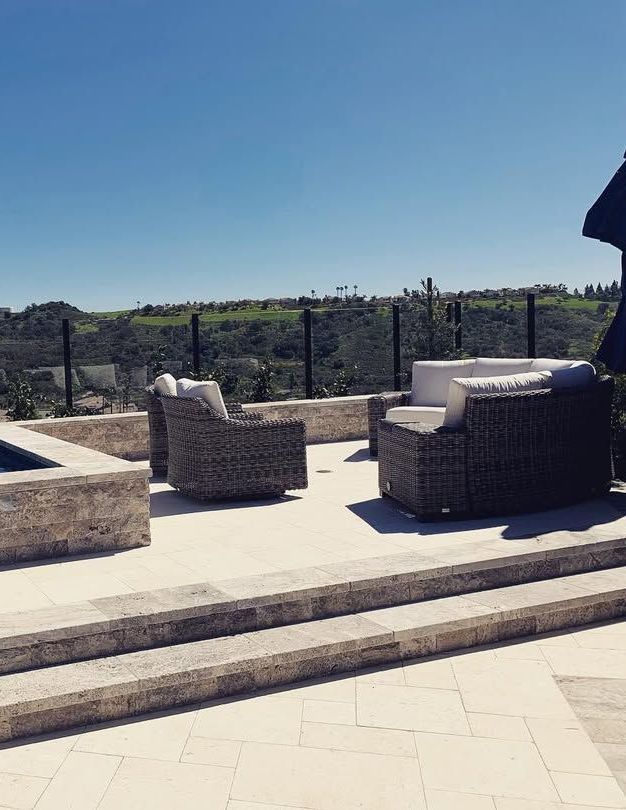 A patio with a couch and chairs and stairs