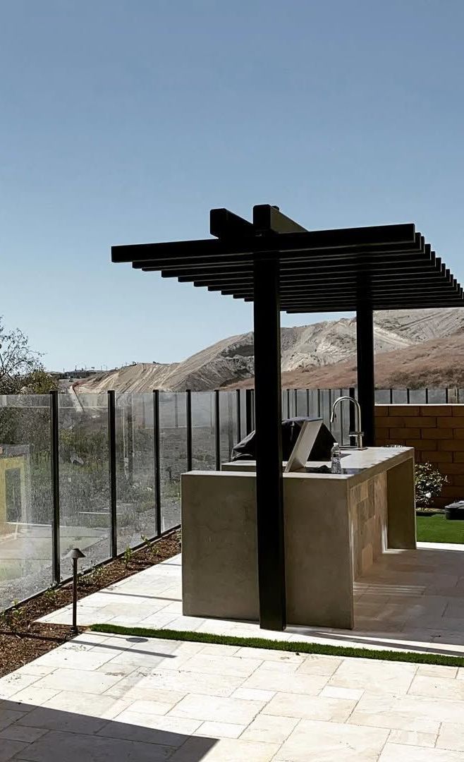 A patio with a pergola and a table underneath it