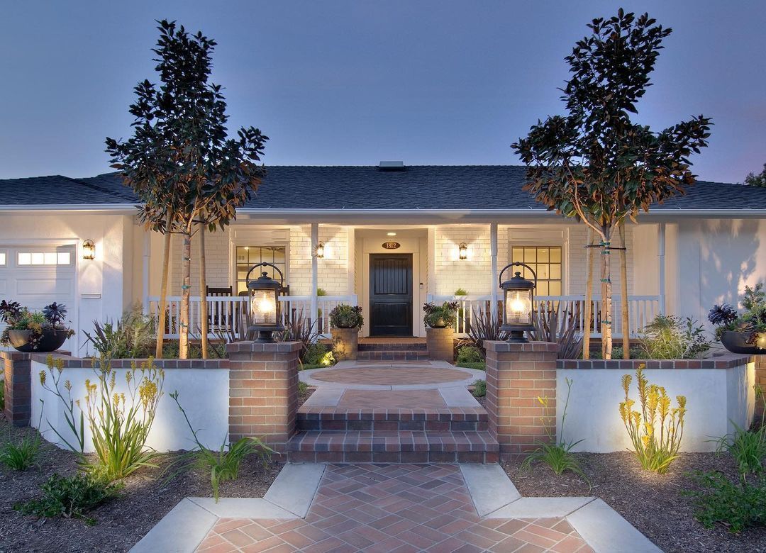 A white house with a black door and a porch