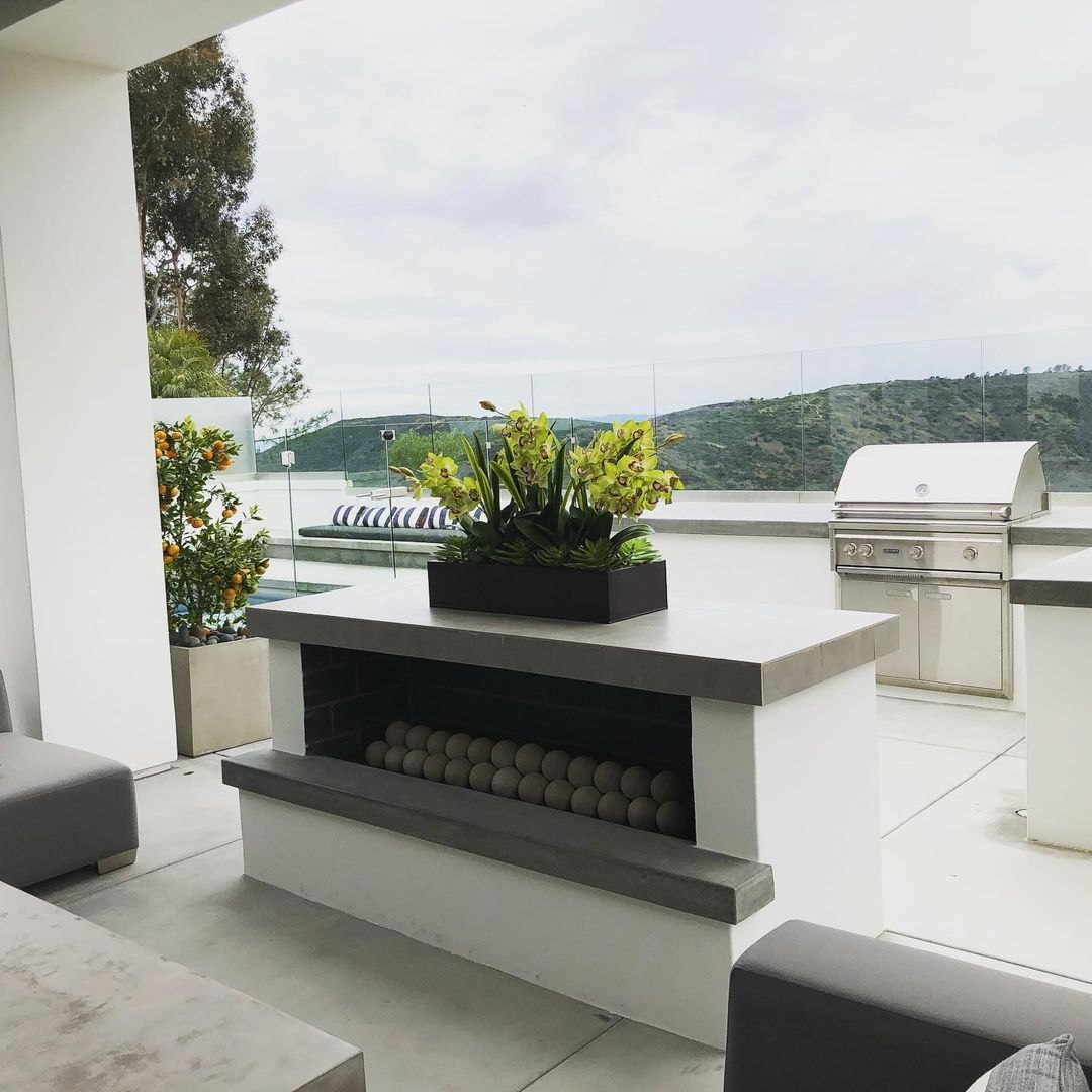 A patio with a fireplace and a view of the ocean