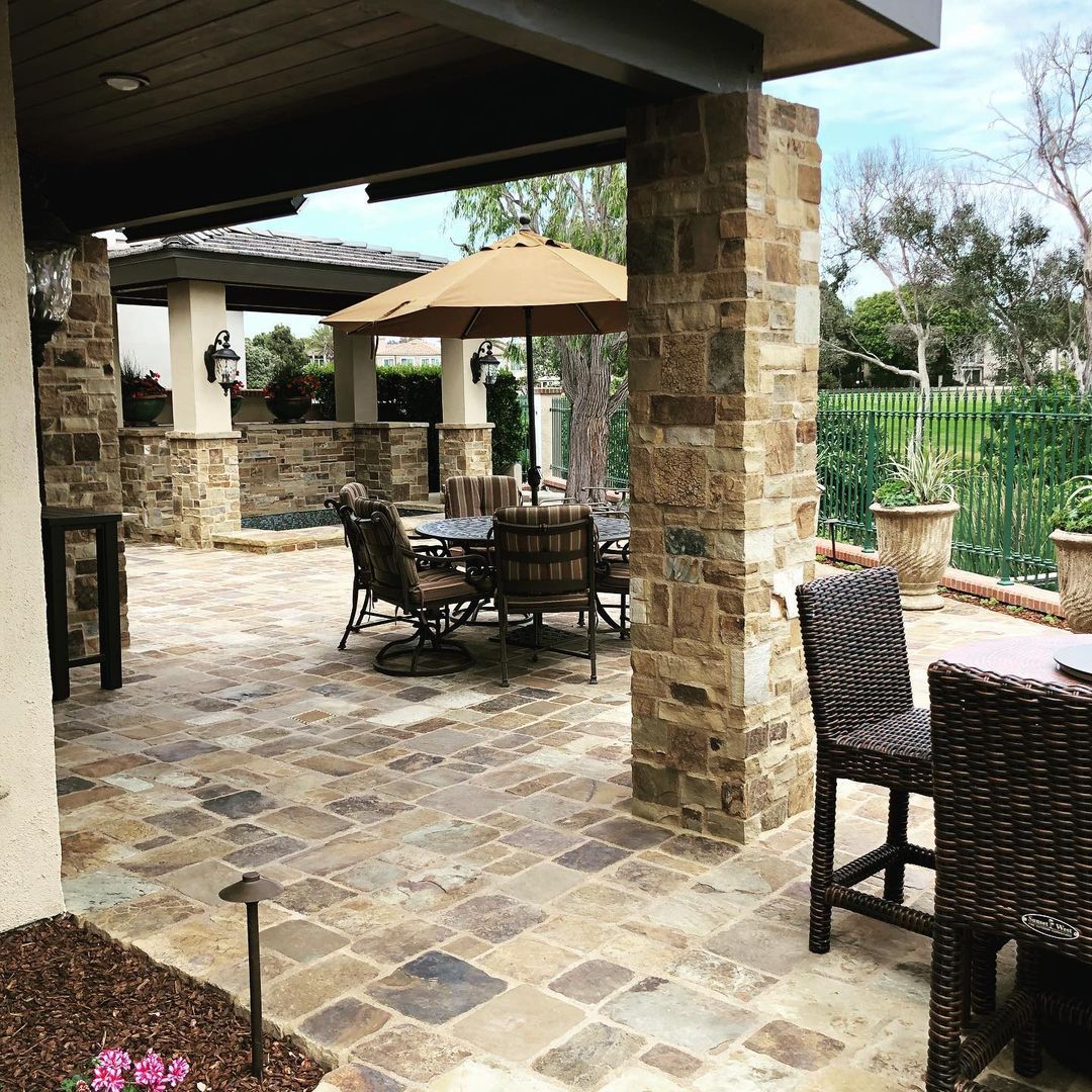 A patio with a table and chairs and umbrellas