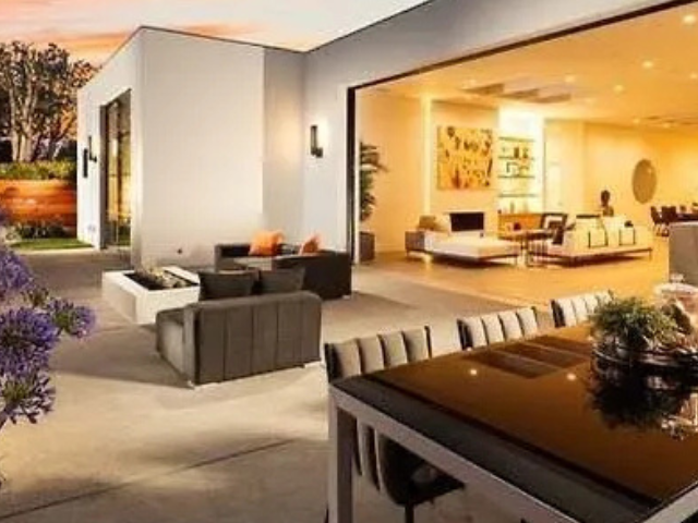 A living room with a table and chairs in front of it