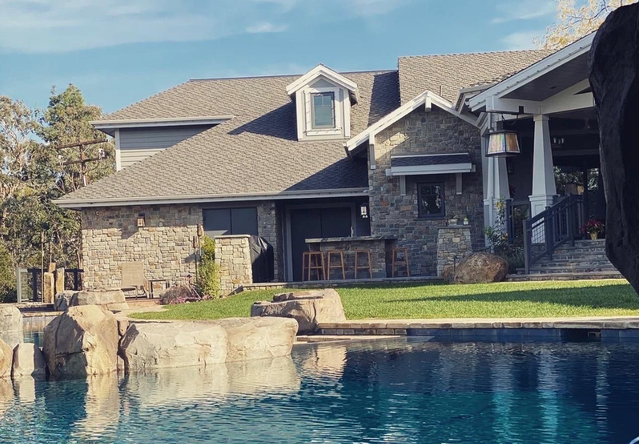A large house with a swimming pool in front of it.