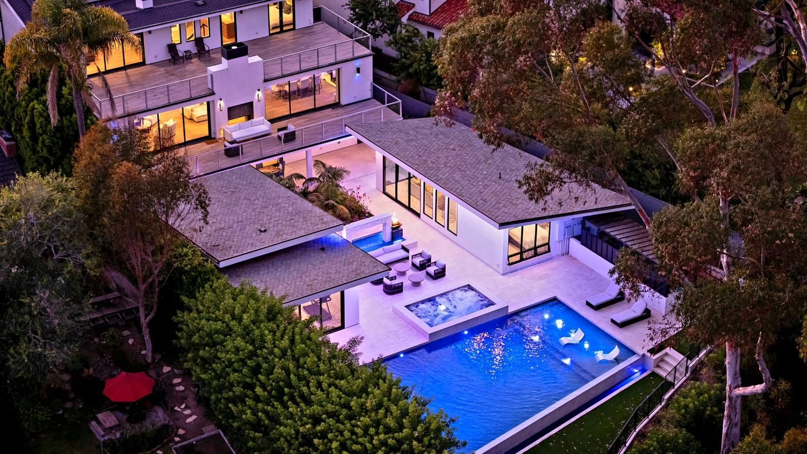 An aerial view of a large house with a swimming pool in the backyard.