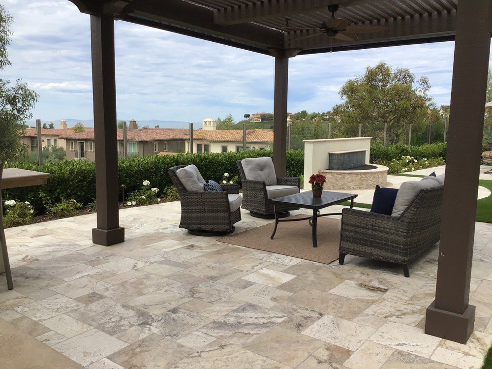 A patio with chairs and a table under a pergola.