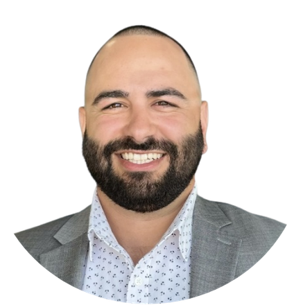 A man with a beard is wearing a suit and smiling