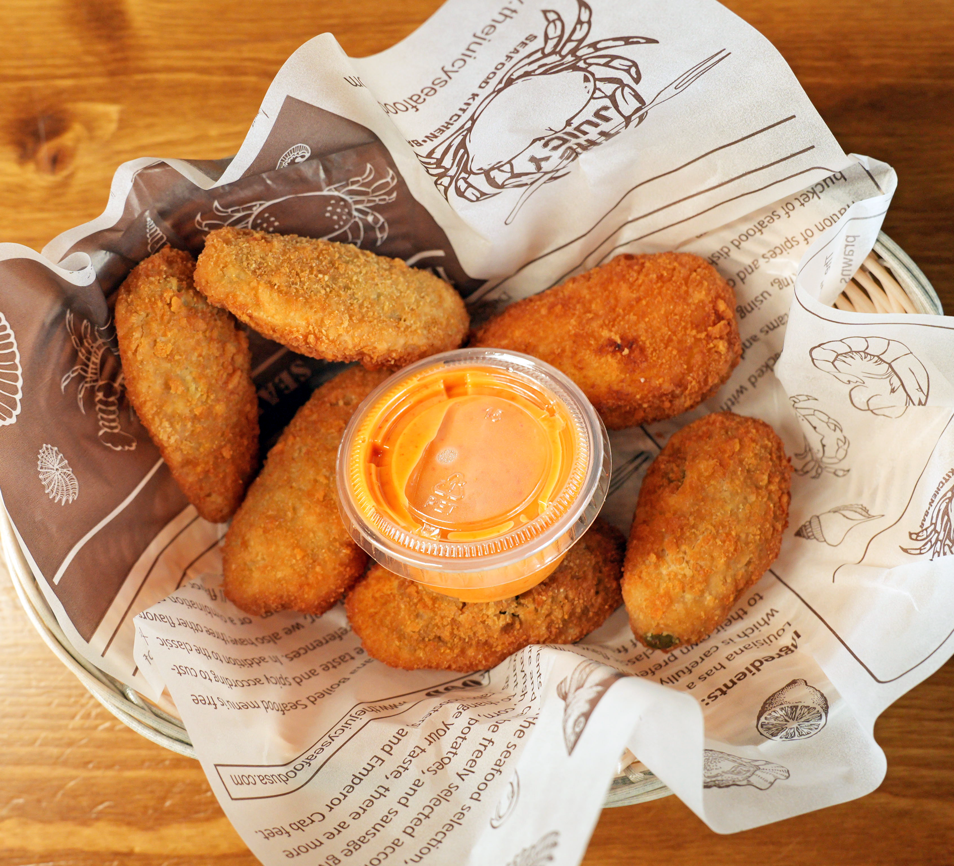 A basket of jalapeno poppers with dipping sauce