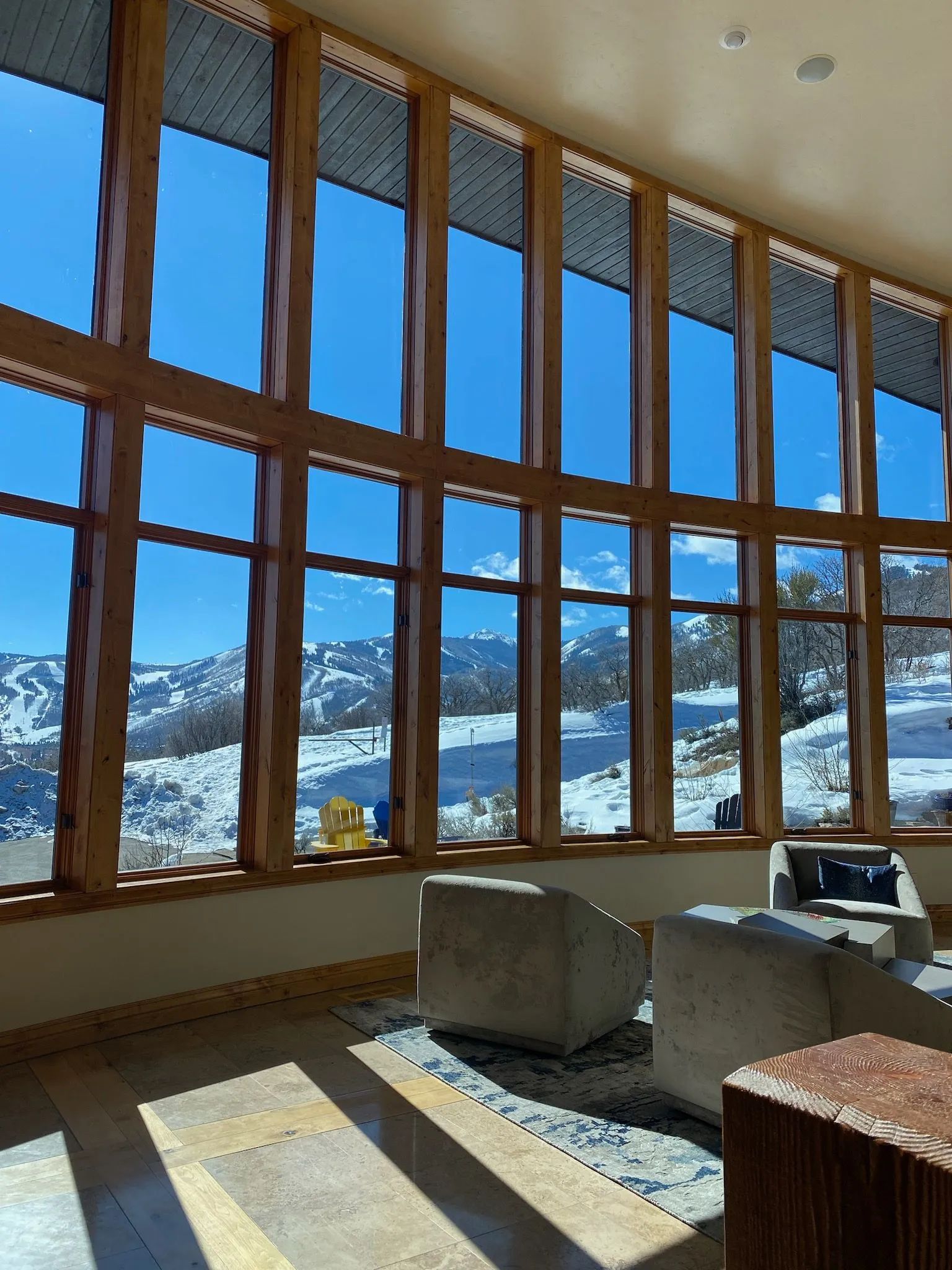 A living room with a lot of windows and a view of the mountains
