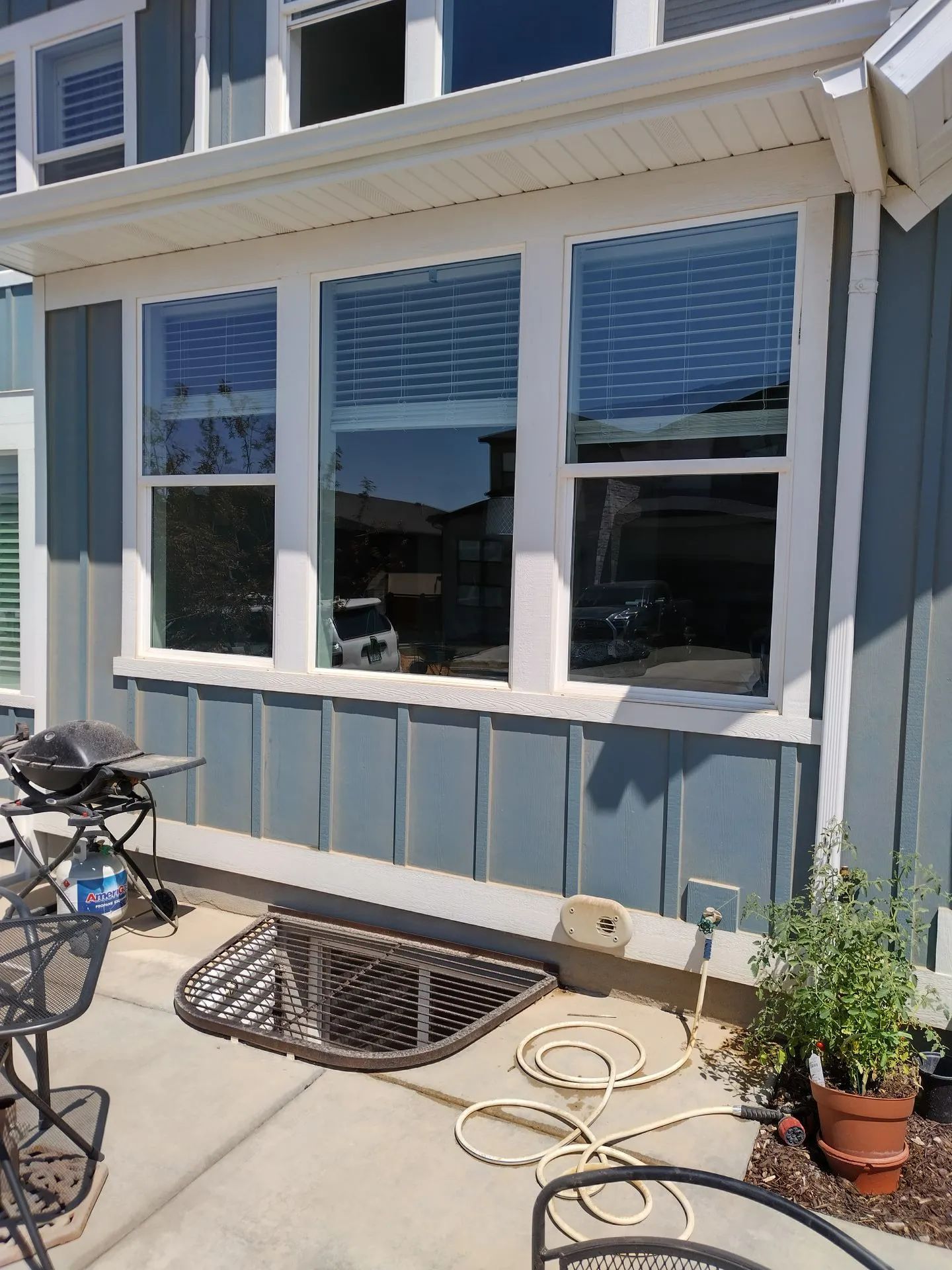 A blue house with white trim and a large window