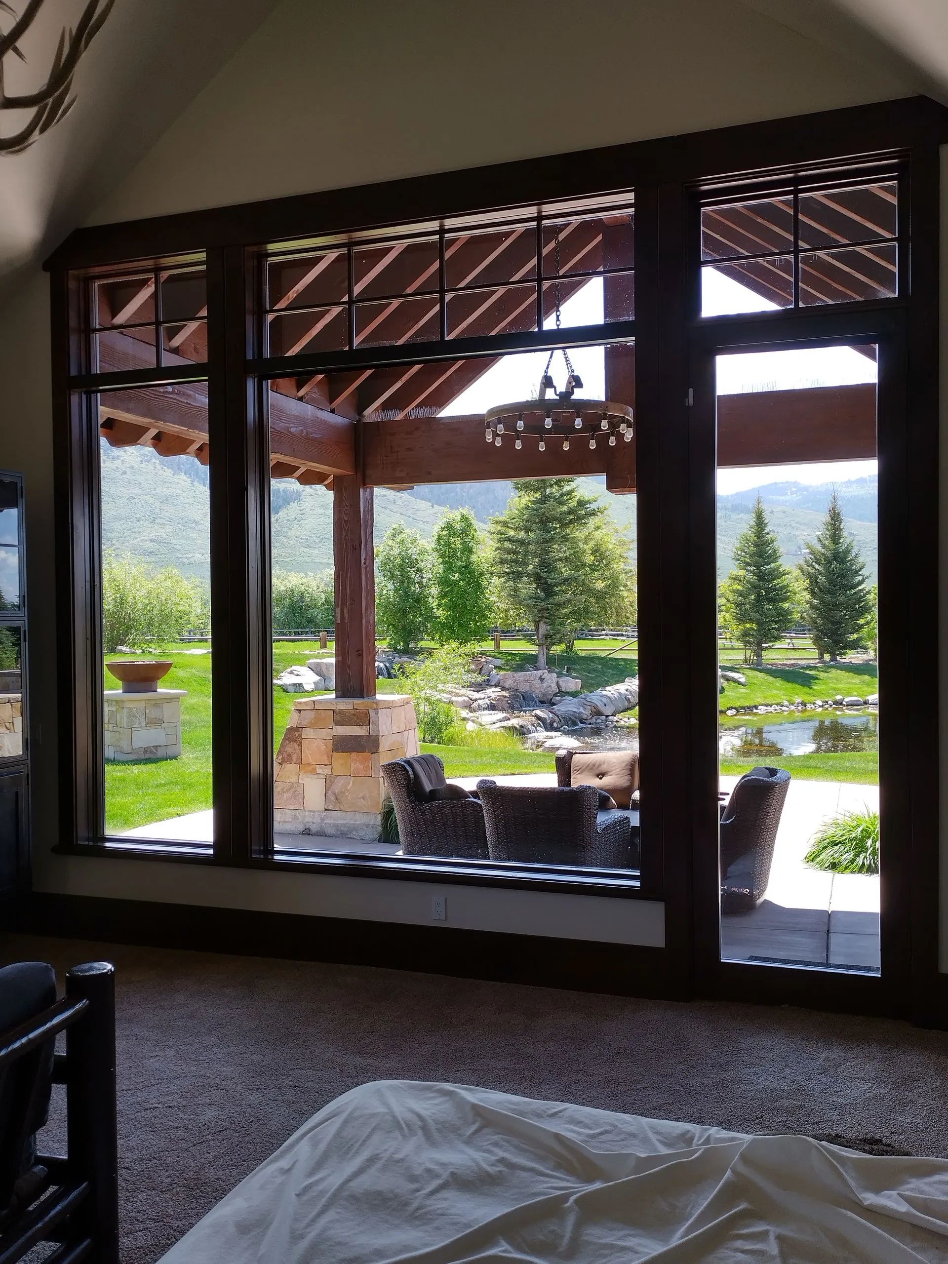 A bedroom with a large window looking out to a patio