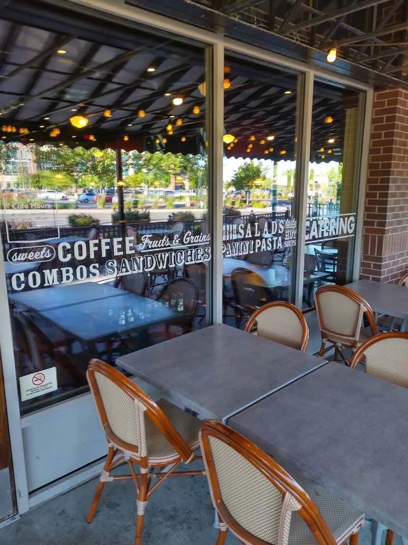 A restaurant with tables and chairs in front of a large window.