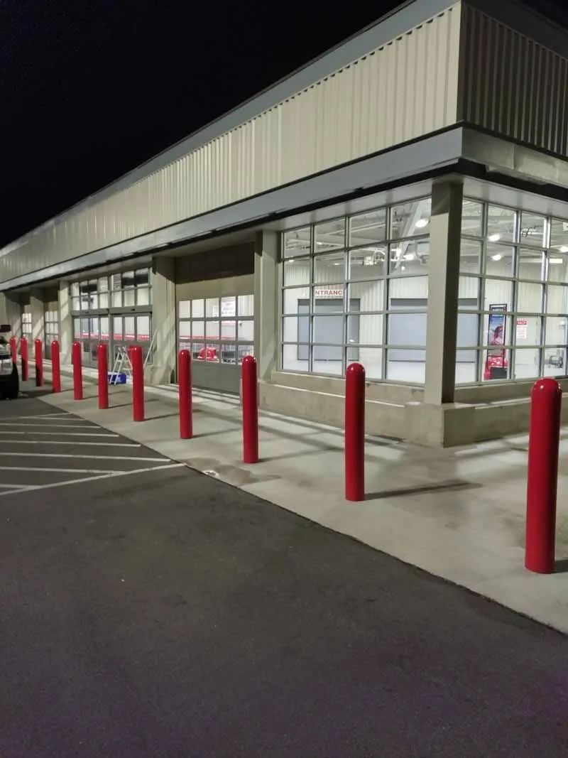 A large building with a lot of windows and red poles in front of it
