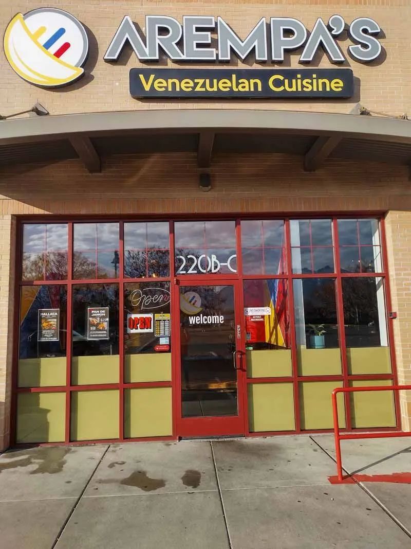 A person wearing purple gloves is cleaning a window with a towel.