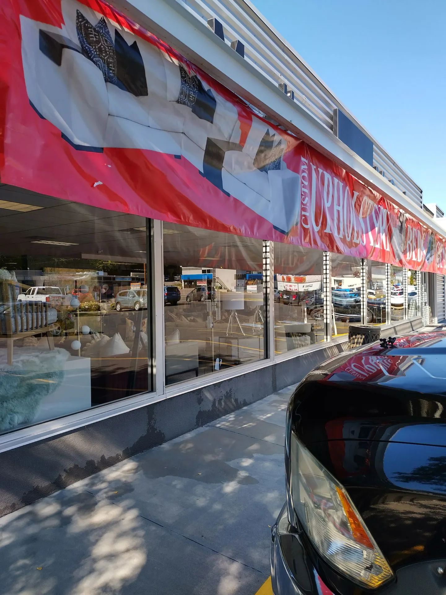 A car is parked in front of a furniture store