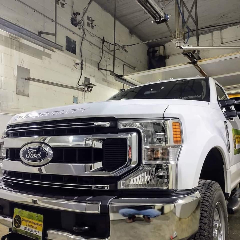 Camion Ford Super Duty blanc dans un garage, face à l'avant.