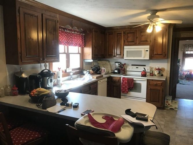 A kitchen with wooden cabinets and a ceiling fan