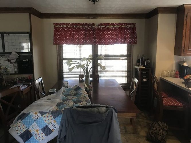 A dining room with a table and chairs and a window