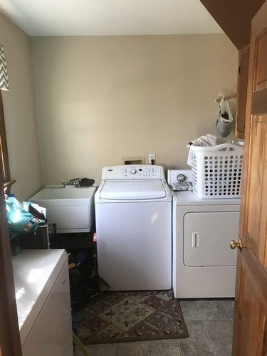 A laundry room with a washer and dryer and a sink.