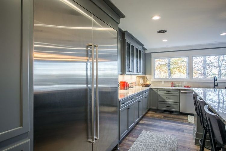 A kitchen with stainless steel appliances and gray cabinets