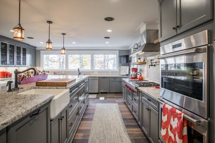 A kitchen with gray cabinets and stainless steel appliances.