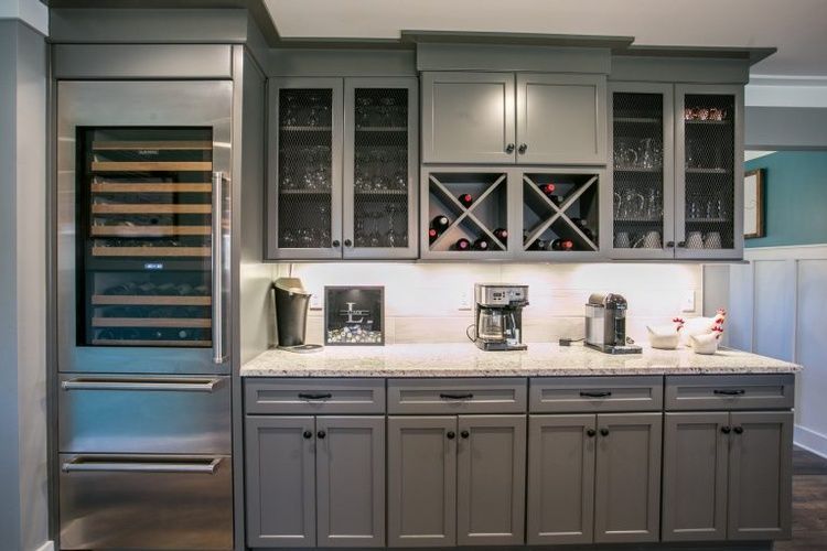 A kitchen with gray cabinets , stainless steel appliances and a wine cooler.