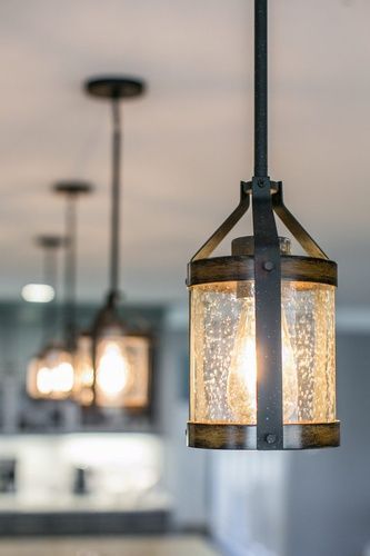 A close up of a pendant light hanging from the ceiling in a kitchen.