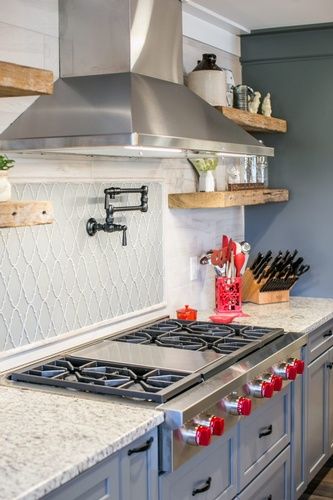 A kitchen with a stove top oven and a stainless steel hood.