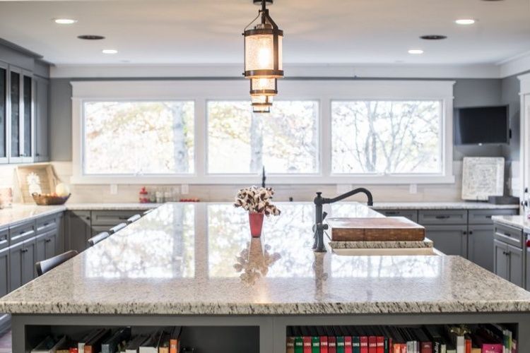 A kitchen with a large island in the middle and a sink.