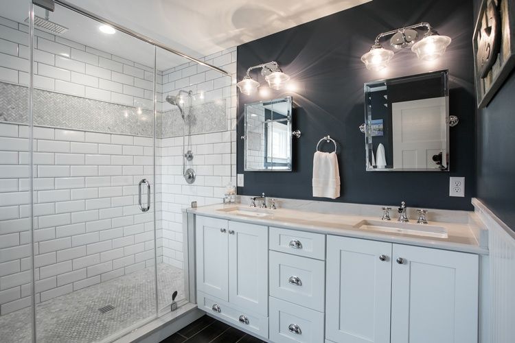 A bathroom with two sinks and a walk in shower.