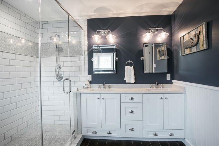 A bathroom with two sinks and a walk in shower.