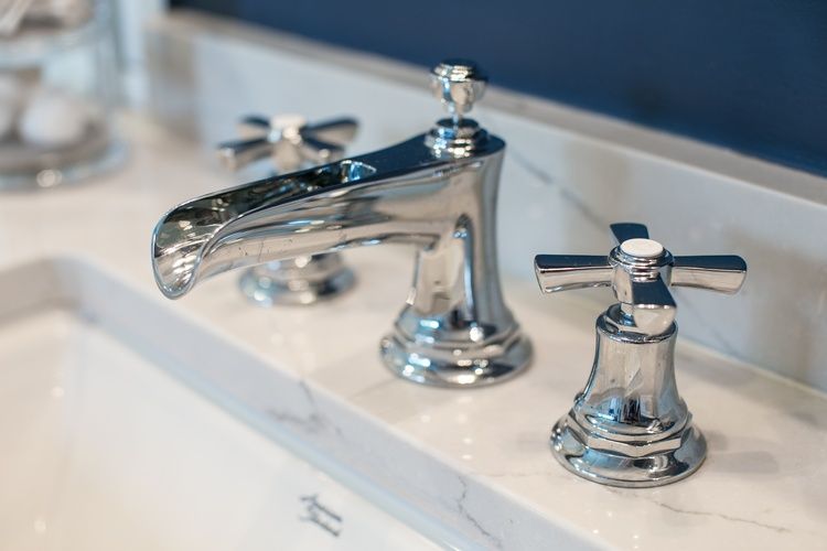 A close up of a bathroom sink with chrome faucets.